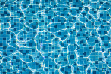 Texture of water surface in swimming pool look transparent to tiles on the floor.の写真素材