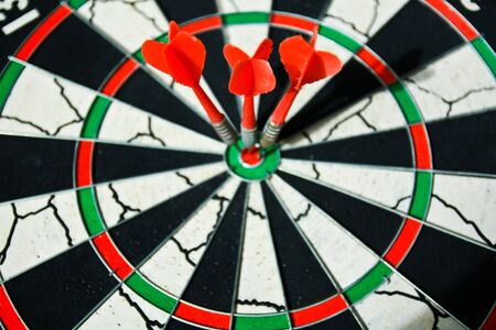 Three darts in bulleye on dart boardの写真素材