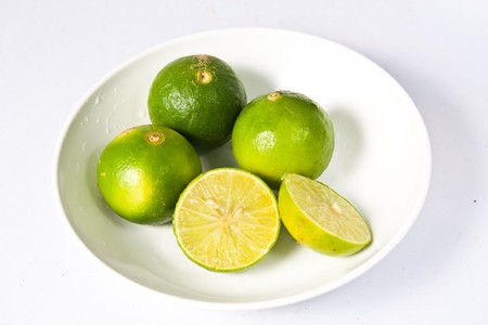 Lemons on white plate isolateの写真素材