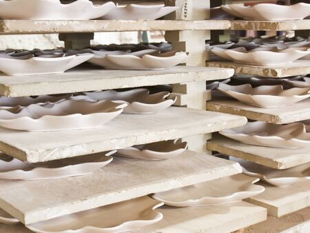 Ceramic plates in racks in ceramic work shopの写真素材