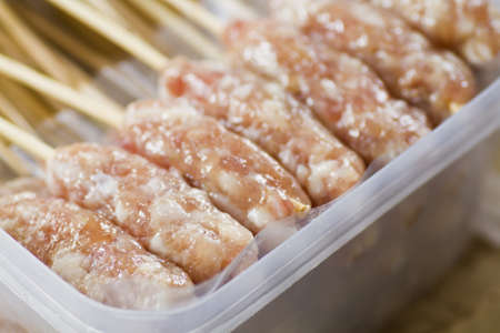 Raw pork prepare for roast with wooden stickの写真素材