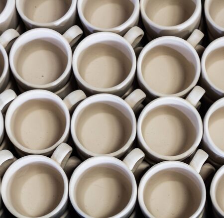 Stack of ceramic mugs in rowの写真素材