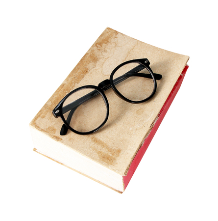 Old book with glasses on white backgroundの写真素材