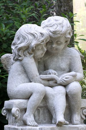 Little cupid statue isolated in the garden background.の写真素材