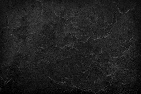 Natural black stone texture. Dark grey black slate background. Black stone wall.の写真素材