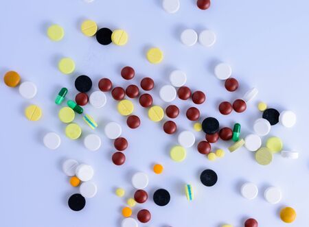 The medicine is out of the bottle on a white table.