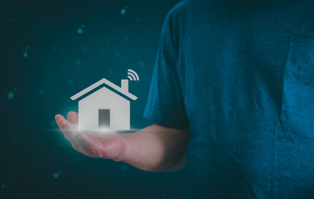 Man using a smartphone, controlling an intelligent home automation system Futuristic interface on a virtual screen Automation technology of things, concept Data connection with technology internet.の写真素材