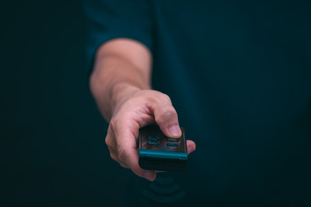 Concepts of using digital media, social media Surfing online, male hand using remote control To play or use social media, the concept of working remotely, working from home via the internet.の写真素材