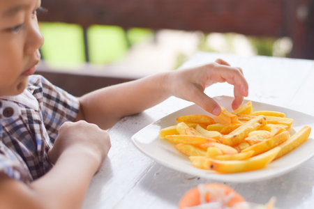 child eating french fries or potato chips.の写真素材