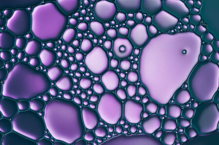 purple oil drops on a water surface abstract backgroundの写真素材