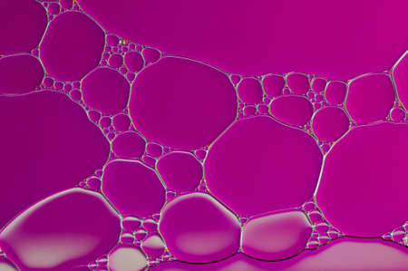 purple oil bubbles on a water surface abstract backgroundの写真素材
