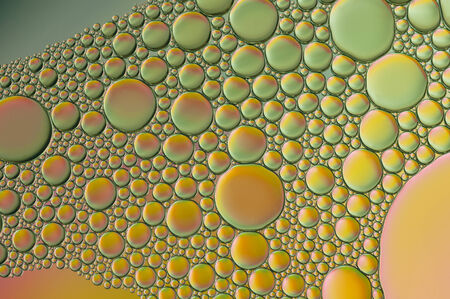 orange oil bubbles on a water surface abstract backgroundの写真素材