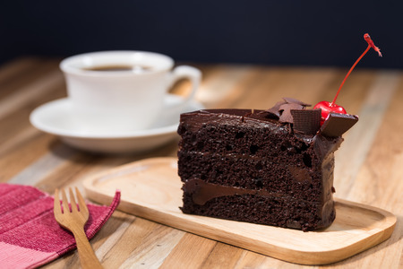 chocolate cake on wooden table with a coffee cupの写真素材