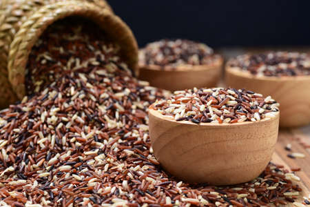 close-up of riceberry rice (black jasmine rice) in wooden cupの写真素材