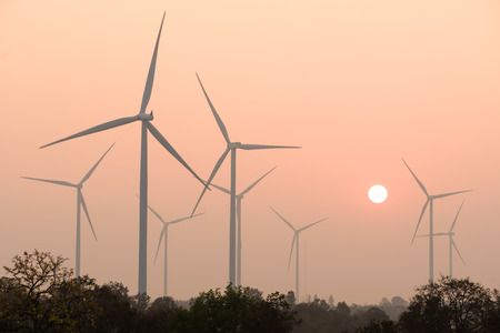 silhouette of wind turbines power generator at sunset