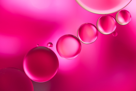 pink oil bubbles on a water surface abstract backgroundの写真素材
