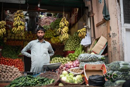 BESHAM, PAKISTAN - April 15, 2018: unidentified man selling fruit and vegetables on the street marketのeditorial素材