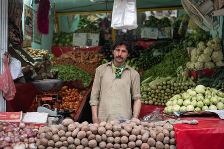 BESHAM, PAKISTAN - April 15, 2018: unidentified man selling fruit and vegetables on the street...