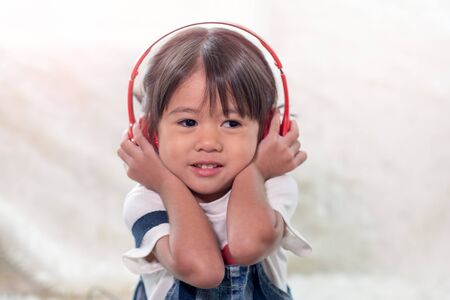 Portrait of happy Asian child enjoy listening to music with headphonesの写真素材