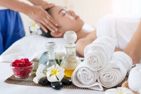 Young Asian woman receiving head massage, enjoying and relaxing in spa salonの写真素材