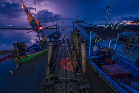 Fishing boat docked by the beach with cloudy sky in the morning, Nature landscapeの写真素材