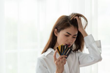 Portrait of Young Asian woman holding credit card with feeling stressedの写真素材