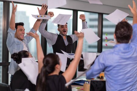 Group of business people celebrating by throwing their business papers and documents fly in air, Power of cooperation, Success teamwork conceptの写真素材