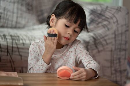 Asian little girl trying make-up cosmetics by themselves