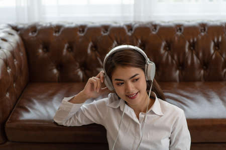 Portrait of Young Asian woman enjoy listening to music with headphones, happy and relaxing timeの写真素材