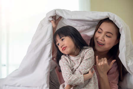 Asian mother tries reconciling with daughter after quarre, family fight concept, generation gap conceptの写真素材