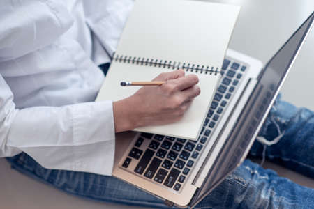 Business Woman hands with pencil writing something on a notebookの写真素材