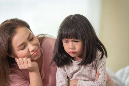 Asian mother tries reconciling with daughter after quarre, family fight concept, generation gap conceptの写真素材