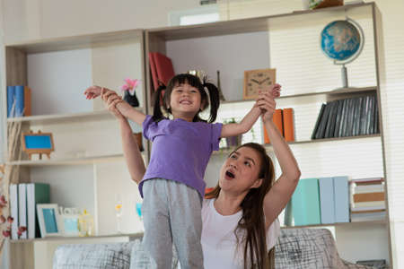 Mother having fun and playing with her daughter at home, Happy Asian little child, family concept