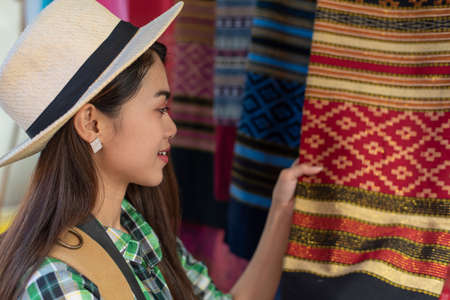 Young Asian female tourist traveling and shopping stall at outdoor local street market in Bangkok...