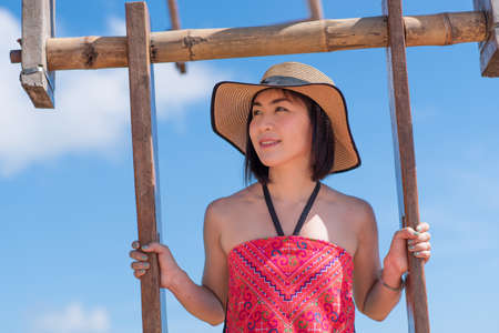 Young Asian female traveler play swing in the highlands of Ban Pha Hee, Mae Sai, Chiang Rai Province, Thailandの写真素材