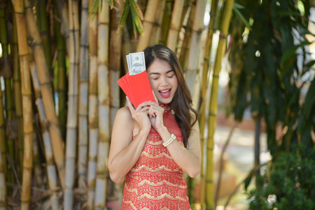 Young happy Asian woman wear cheongsam holding red envelopes in Chinese New Yearの写真素材