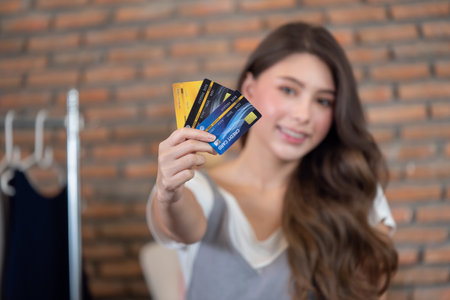 Close-up of woman holding credit card for online shoppingの写真素材