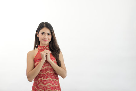 Young happy Asian woman with congratulatory gesture in Chinese New Year on white backgroundの写真素材