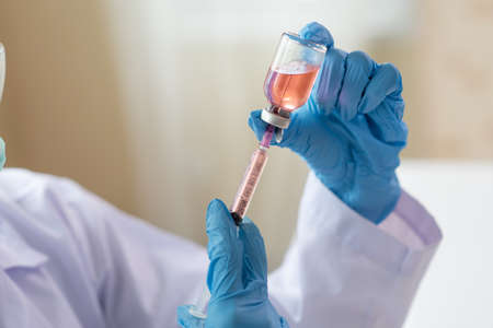 Close up of Female doctor or scientist holding syringe and vaccine, Science and chemistry, Healthcare and Medical conceptの写真素材