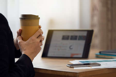 Close up of a business woman hands holding coffee cup in the morningの写真素材