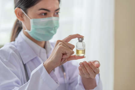 Close-up of female doctor holding a bottle of vaccine, Healthcare and Medical conceptの写真素材