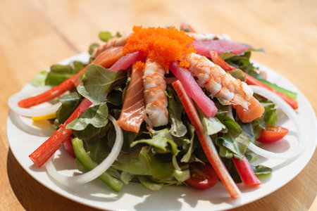 Spicy Salmon and shrimp Salad with fresh green vegetable in white plateの写真素材