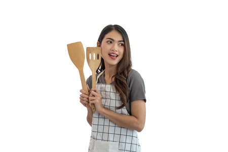 Young Asian woman cook holding a wooden spatula isolated on white backgroundの写真素材