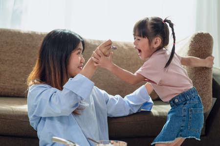 Happy Asian child enjoy eating ice cream with her older sister, love and happiness family concept