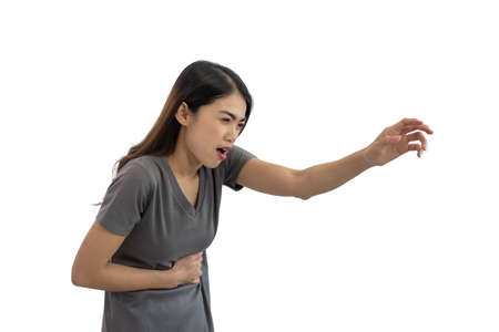 Unhealthy Asian woman hands touching her belly isolated on white background, Looking like stomach pain, Healthcare conceptの写真素材