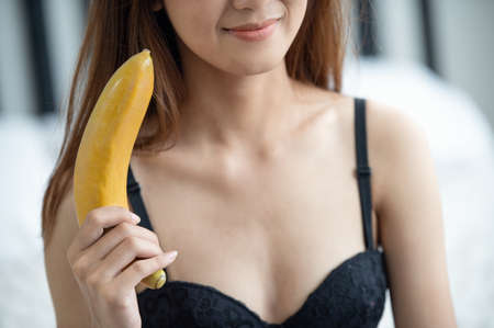 Close-up of young sexy attractive Asian women holding a bananaの写真素材