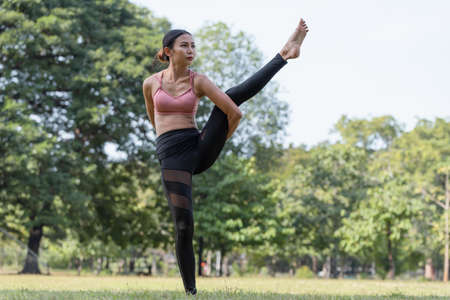 Sporty Asian woman doing yoga exercise and relax with sportswear in park, sport and healthy...
