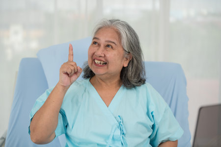 Happy Asian female senior patient smiling, raised her hand to show confidence in treatment, elderly...
