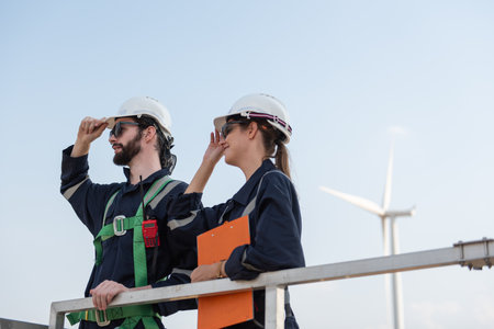 Engineers working on site in wind turbine farm, Wind turbines generate clean energy source, Eco...