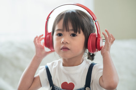 Portrait of happy Asian child enjoy listening to music with headphonesの写真素材